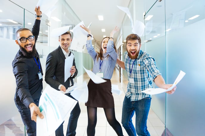 Group of joyful excited business people holding sheets of paper