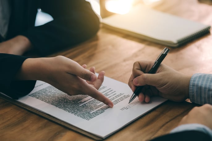 A person prepares to sign a document.