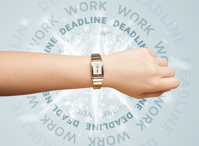 An arm wearing a watch with the words 'work' and 'deadline' in the background.